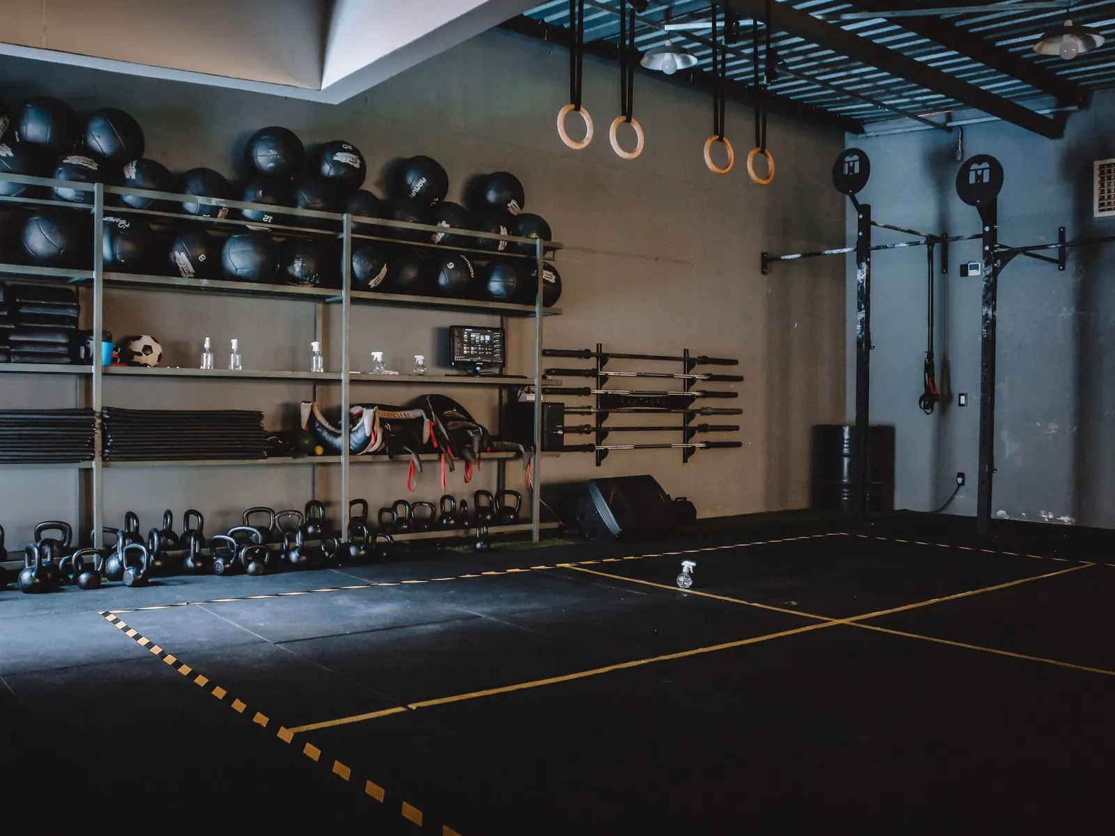 Exercise studio with medicine balls, kettlebells, rings and a cushioned floor